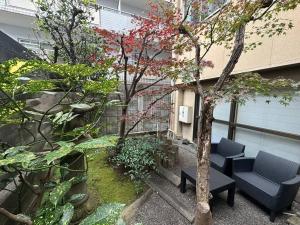 a garden with two chairs and a tree in a building at Yuririan in Kyoto