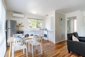 a kitchen and living room with a table and chairs at Bells Beach Cottages in Bellbrae