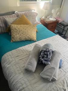 un letto con coperta e cuscini sopra di TINY HOME - Benny’s Bar a Lake Munmorah