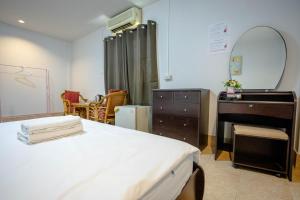 Un dormitorio con una cama, una cómoda y un espejo. en Mitr Inn HuaHin Beach, en Hua Hin