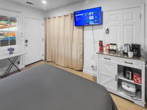 ein Zimmer mit einem Fernseher an der Wand und einem Schreibtisch in der Unterkunft Downtown San Jose Priv Entry Priv Bath SJSU and AC in San Jose