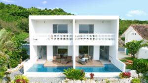 an aerial view of a white house with a swimming pool at 琉球李邸インギャー in Arazato