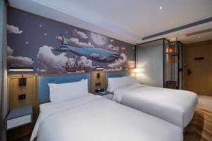 Dos camas en una habitación con un cuadro en la pared. en 景星王府井协和医院店, en Beijing