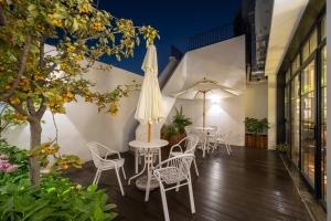 Un patio con mesas y sillas y una sombrilla. en 景星王府井协和医院店, en Beijing