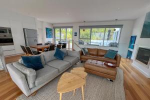 a living room with a couch and a table at BEACHHOUSE BINALONG Luxury waterfront holiday house at Bay of Fires in Binalong Bay
