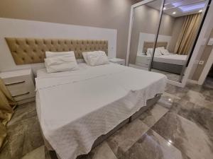 a bedroom with a large white bed and a mirror at Kuzey Adana'da merkezi konumda in Kurttepe