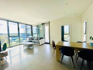 a living room with a table and chairs and a couch at Modern stylish 3 bedroom condo - Parking, Gym, Pool in Sydney