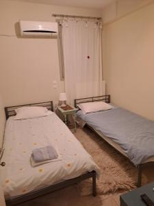 two twin beds in a room with a window at Sunset at Cape Sounio in Sounio