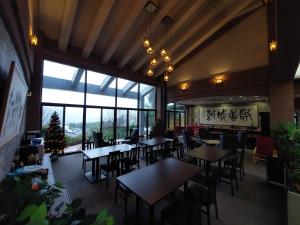 由布市ゆけむり山荘的一间餐厅,配有桌椅和圣诞树