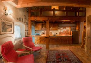 a kitchen with wooden cabinets and red chairs in a room at Castel Madonna in San Martino di Castrozza