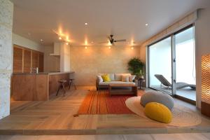 a living room with a couch and a kitchen at 琉球李邸インギャー in Arazato +19 photos