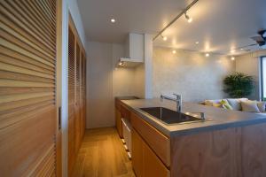 a kitchen with a sink and a couch at 琉球李邸インギャー in Arazato
