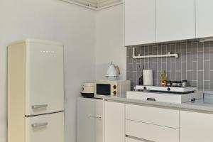 a kitchen with white cabinets and a white refrigerator at Songnae Forestay in Bucheon