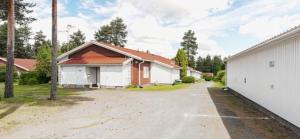 a house with a driveway next to a building at Paukavuori in Seinäjoki