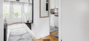 a kitchen with white cabinets and a door with a window at Paukavuori in Seinäjoki +5 photos