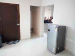 a kitchen with a stainless steel refrigerator in a room at Aster Suites in Bangalore