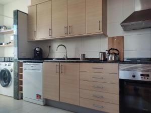 a kitchen with wooden cabinets and a washer and dryer at Ap4Us B1 - Apartment for us - Sightseeing & Beach near to Barcelona in Badalona