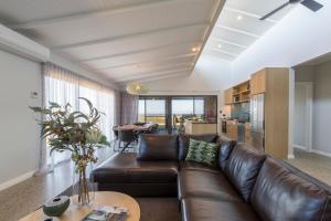 a living room with a brown leather couch and a table at Parrys Estate at Parry Beach in Parryville