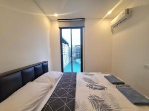 a bedroom with a bed and a large window at The Modern A27 Hua-Hin Private Poolvilla from beach 3km in Hua Hin +9 photos