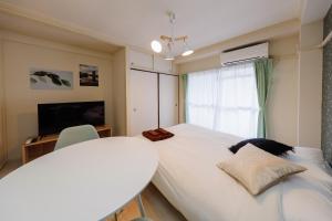 een slaapkamer met een groot wit bed en een raam bij Kimura House in Tokyo