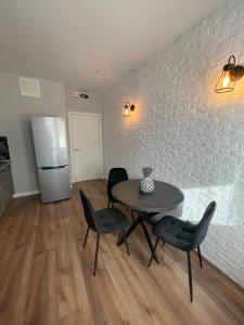 a kitchen with a table and chairs and a refrigerator at Alba Iulia Residence in Chişinău