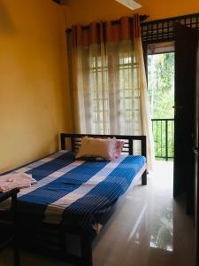une chambre avec un lit dans une pièce avec une fenêtre dans l'établissement Matara Heritage Home - Local Family Stay, à Matara