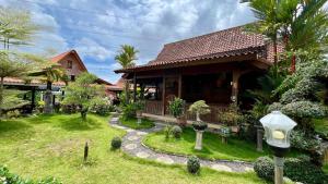 a house with a garden and a street light at OKU Guest House in Giri