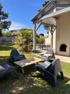 a group of chairs and a picnic table in a yard at Maison Familiale bord de mer in Préfailles