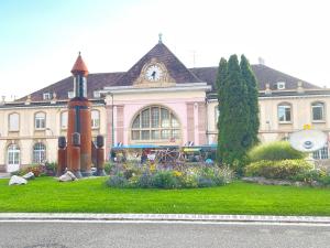 Un gran edificio con un reloj encima. en AbraCadabra Flat France Suisse, en Saint-Louis