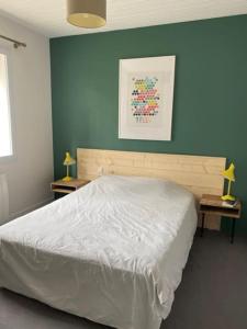 a bedroom with a white bed and a blue wall at Maison Familiale bord de mer in Préfailles