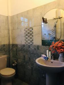 une salle de bain avec un lavabo, des toilettes et un miroir dans l'établissement Matara Heritage Home - Local Family Stay, à Matara