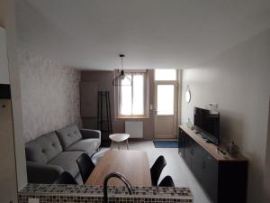 a living room with a couch and a table at Maison Montebello in Sézanne