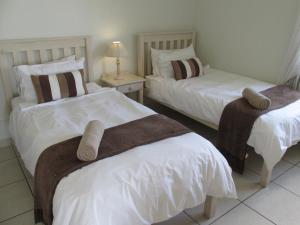 a bedroom with two beds with towels on them at Point Village Accommodation - Alista in Mossel Bay
