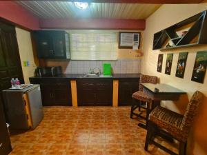 a kitchen with a sink and a table and chairs at Monte Rio Gardens Bed & Breakfast in Alaminos