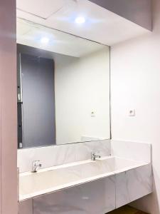 bagno con grande specchio e lavandino di Hotel Shakti Capsule a Bandung Altre 9 foto