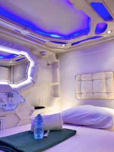 una camera da letto con una bottiglia d'acqua appoggiata sul letto di Hotel Shakti Capsule a Bandung