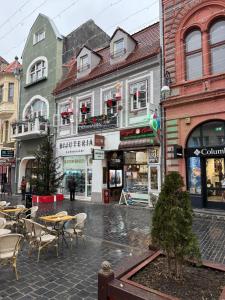 a city street with tables and chairs and buildings at House 54 in Braşov