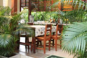 a restaurant with a table and chairs and plants at Huen Chan Thip in Chiang Rai