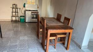 a wooden table and chairs in a kitchen with a stove at Soa Land villa in Antananarivo