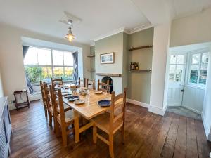 a dining room with a wooden table and chairs at Glannant - 5 Bed & 4 Bathroom - Fairbourne, Barmouth, Mawddach Estuary in Arthog