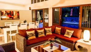 a living room with a red couch and a table at Palm View Villa in Lamai