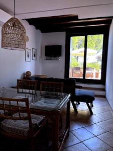 Una sala de estar con una mesa y sillas y un televisor. en Portopollo sea view apartment Zero budget, en Palau