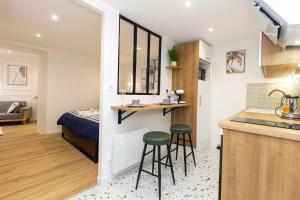 a kitchen with two stools in a small room with a bed at Chic & beau au centre Millau in Millau