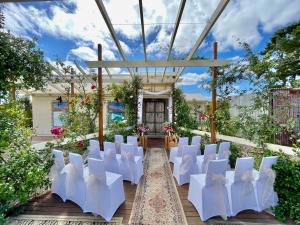 a set up for a wedding in a garden with white chairs at Love at Sellicks Chills in Sellicks Hill