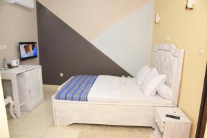 a bedroom with a bed and a tv in it at Gamo Hotel in Yaoundé