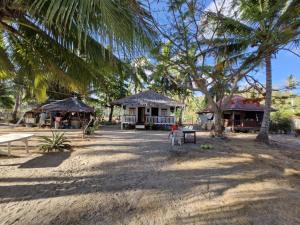 a person sitting on a chair in front of a house at White Hat EL NIDO in El Nido