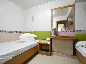 um pequeno quarto com um espelho e uma cama em Astronaut's Hotel em Hong Kong