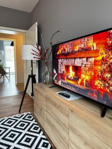 a living room with a large television with a fireplace at Haus Gitta - Wohlfühlen & Genießen in Luckenwalde