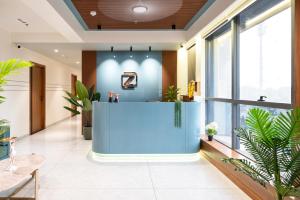甘地讷格尔The Zuree Hotel的办公室大厅,有蓝色的柜台和植物