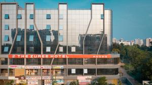 甘地讷格尔The Zuree Hotel的一座大建筑,上面有红色的标志